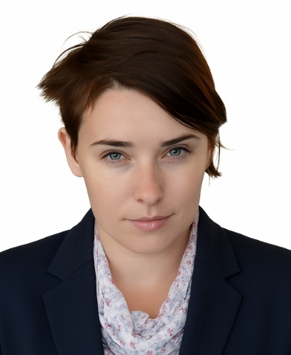 Monika Plata – portret formalny. Młoda kobieta o krótkich, ciemnobrązowych włosach i spokojnym wyrazie twarzy. Ubrana w granatową marynarkę i jasną chustę w delikatny wzór kwiatowy.